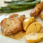 A plate of pork medallions with an apple and sage sauce.