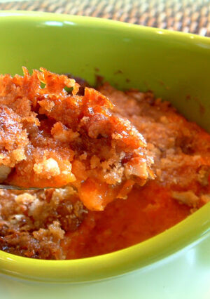 A bowl of sweet potato casserole with a forkful.