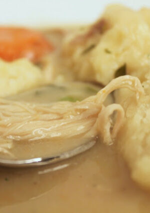 A bowl of chicken soup and dumplings.