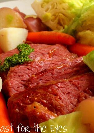 Corned Beef and Cabbage is slowly oven braised for several hours. A tangy glaze of apple cider vinegar and brown sugar adds an extra layer of delicious favor.