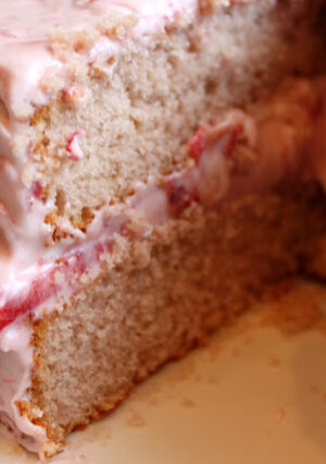 This Homemade Strawberry Cake is not made with box cake mix and jello. I much prefer to make cakes the old-fashioned way, with pantry ingredients and real strawberries. The frosting is a blend of butter and cream cheese. Strawberry pulp turns the frosting a pretty pink, with bits of strawberries. This cake is a show stopper! The frosting was off-the-charts delicious!