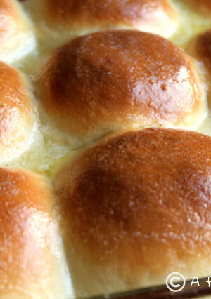 A pan of buttered dinner rolls.
