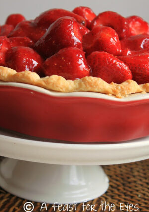 This Strawberry Pie features fresh, uncooked, strawberries. The pie is finished with a homemade glaze, made with pureed strawberries. The glaze highlights the sweetness of the berries. The pie crust is tender and buttery-- and has a secret ingredient that makes this the perfect pie crust.