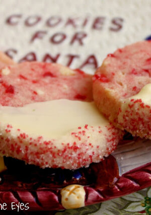 A plate of white chocolate dipped cherry shortbread cookies.