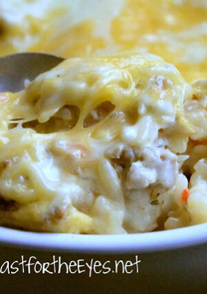 A spoonful of potato casserole with melted cheese.