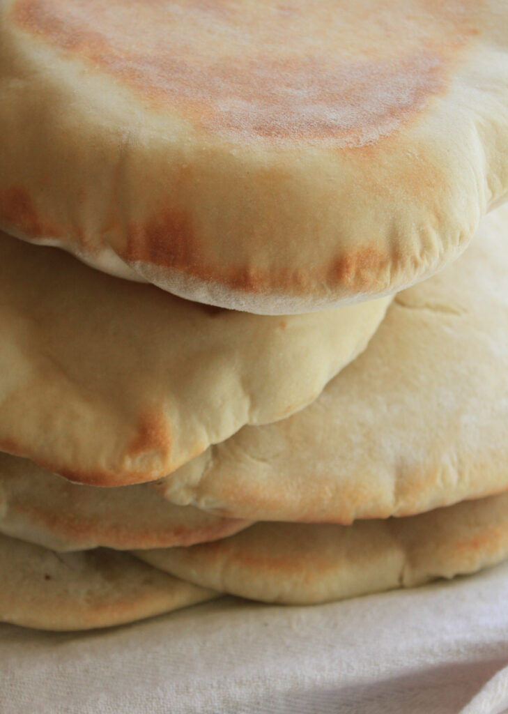 This Greek-Style Pita bread is surprisingly easy to make at home and so much better than the dry and tough versions that comes in bags from the grocery store. The dough is a breeze to work with, and puffs up beautifully in the oven, then relaxes to a "pita pocket" bread that has endless "stuffing" possibilities. We particularly enjoy this bread with homemade Ground Lamb Gyros. 