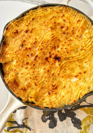 A skillet of seafood pie topped with golden mashed potatoes,