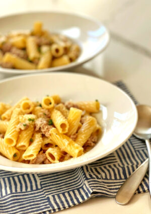 For a quick weeknight meal, this Rigatoni with pork sausage and chives is a comforting meal. The sauce is made with shallots, reduced white wine and heavy cream. Garnished with Parmesan cheese and chives, this dish is both filling and delicious.