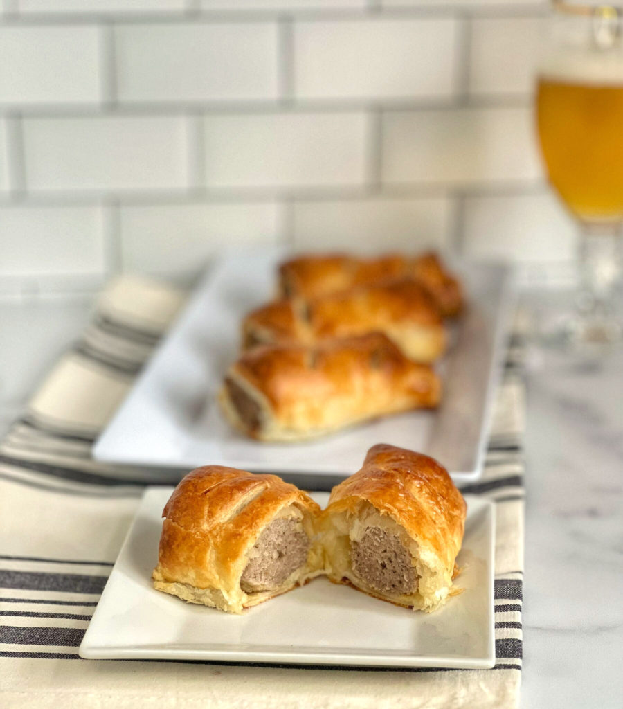 These British Sausage Rolls are a savory appetizer, snack or main meal and they are absolutely delicious! Seasoned ground pork is encased in puff pastry, and baked until golden brown. They are a perfect make ahead recipe and are utterly addictive!