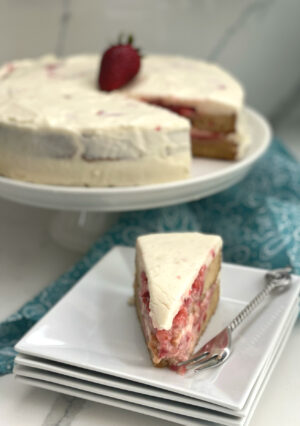 This Strawberry Shortcake Cake is made with an easy homemade sponge cake. Crushed and slightly sweetened fresh strawberries is the filling and cake is frosted with a creamy and dreamy cream cheese frosting! This is one of my favorite summer pot luck desserts that will please a crowd.