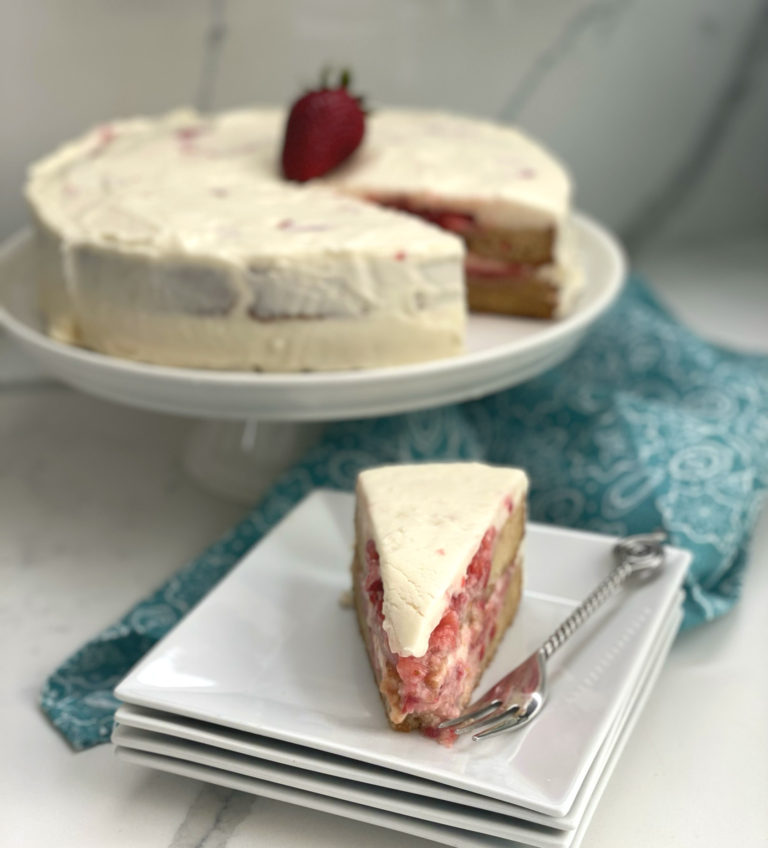 This Strawberry Shortcake Cake is made with an easy homemade sponge cake. Crushed and slightly sweetened fresh strawberries is the filling and cake is frosted with a creamy and dreamy cream cheese frosting! This is one of my favorite summer pot luck desserts that will please a crowd.