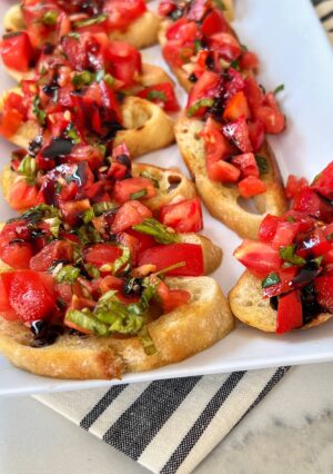 Bruschetta is an Italian antipasto consisting of grilled bread often topped with olive oil and salt. Most commonly it is served with toppings of tomatoes, seasoned with fresh garlic, salt and fresh basil. Other variations can be toppings of vegetables, beans, cured meat, and/or cheese. When summer tomatoes are in season, this is an irresistible and easy appetizer. Watch them disappear!