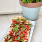 Fresh Tomato Bruschetta, grilled on homemade pizza dough, is a perfect way to enjoy summer tomatoes and basil. This homemade pizza dough can be made in advance. This is even better than pizza delivery, for a lot less money.