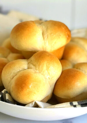 A plate of golden baked dinner rolls.