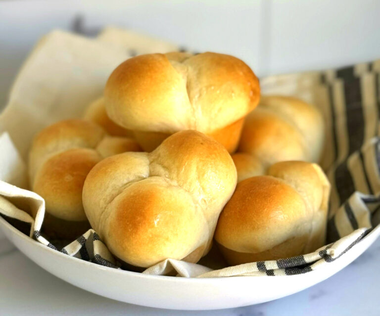 A plate of golden baked dinner rolls.