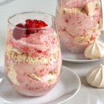 A dish of strawberry puree' and whipped cream with a layer of meringue cookies.